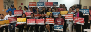 A group of organizers from Pilipino Workers Center, holding rally signs. Myrla is on the right.