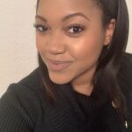 A headshot of Angelena, a Black woman, facing the camera at a 3/4 angle and smiles