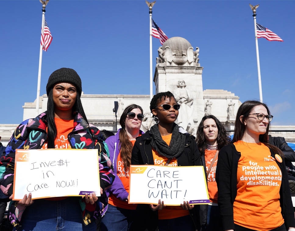 Activists of different ethnicities hold signs that read 